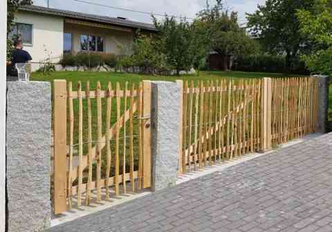 Staketenzaun-Tür und Tor zwischen Granitsäulen