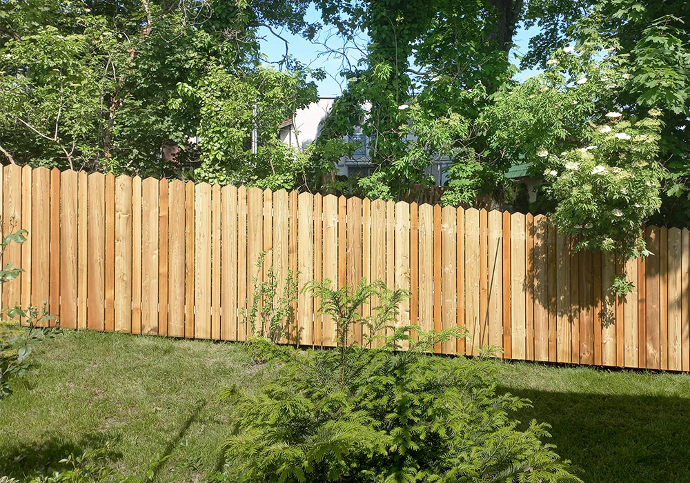 Bretter oben gespitzt, schräg dem Gelände angepasst